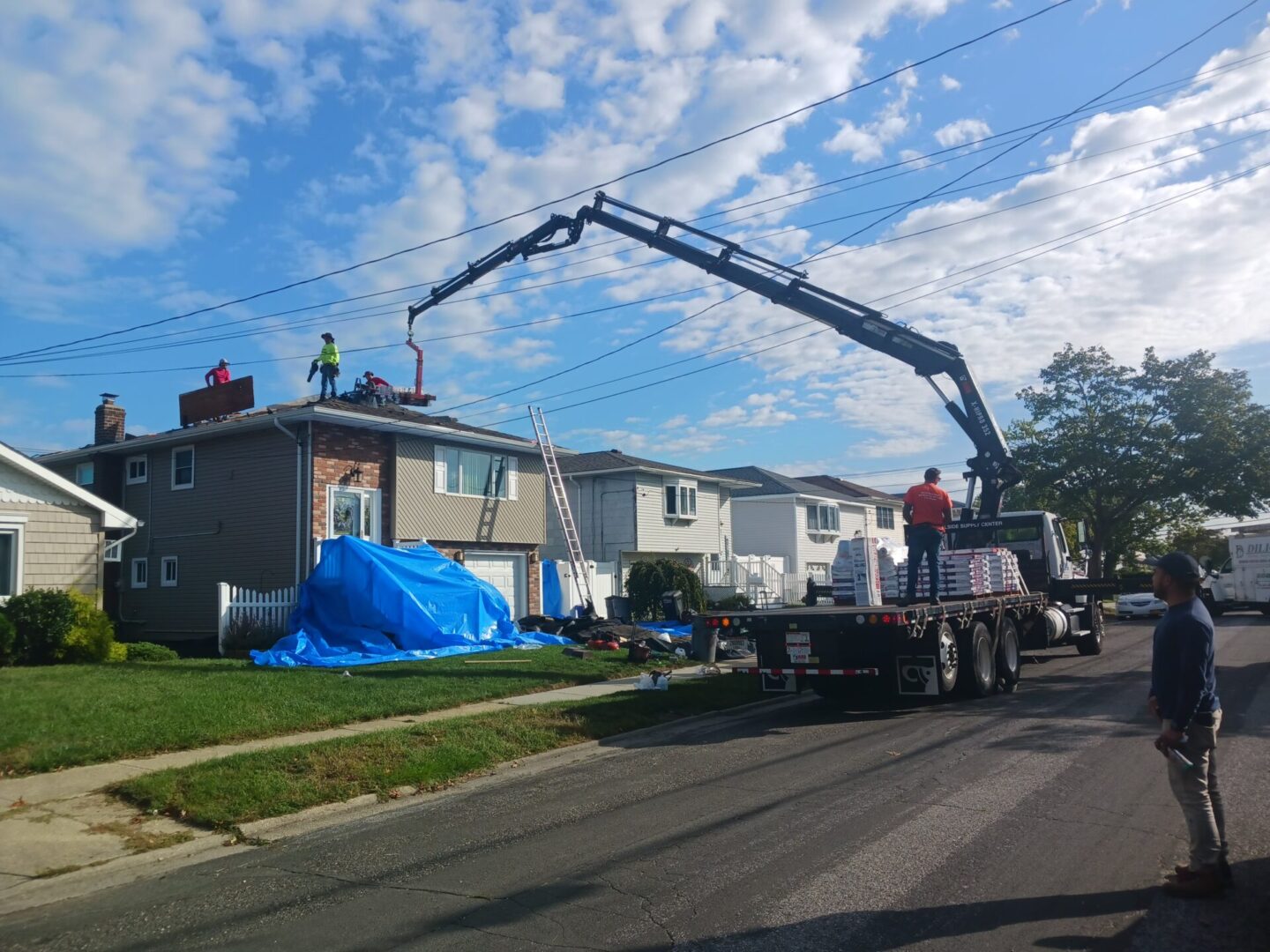 A crane is being used to lift the roof of a house.